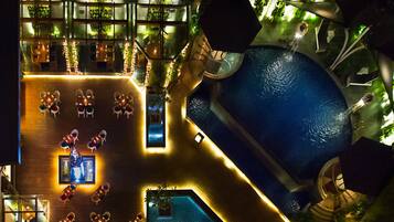 Relax and unwind on our spacious rooftop terrace, featuring a central pool and comfortable seating areas surrounded by lush greenery.