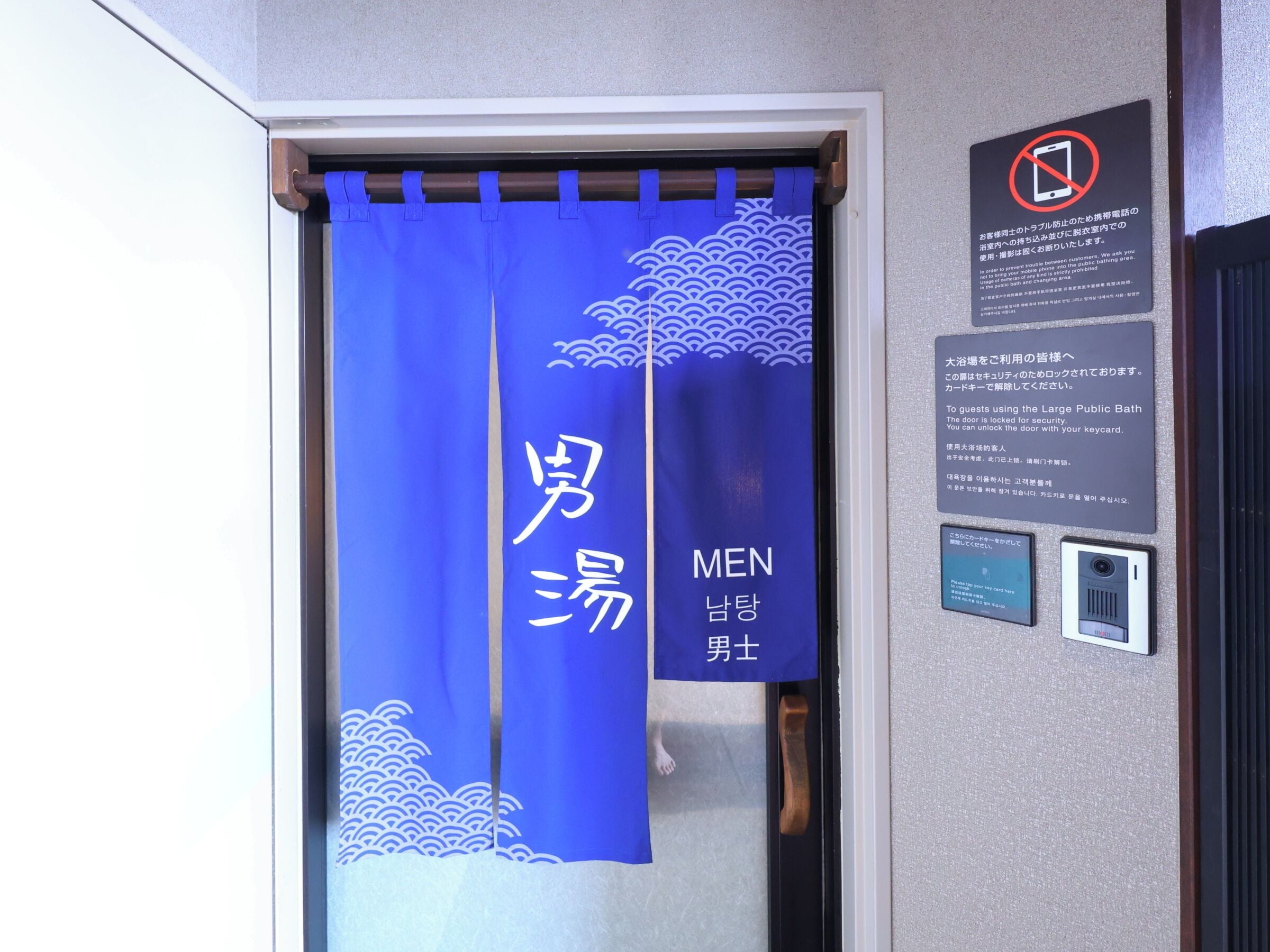 A blue curtain with 'MEN' written on it, indicating a men's restroom.