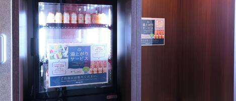A vending machine with a menu board displaying various drink options and prices.