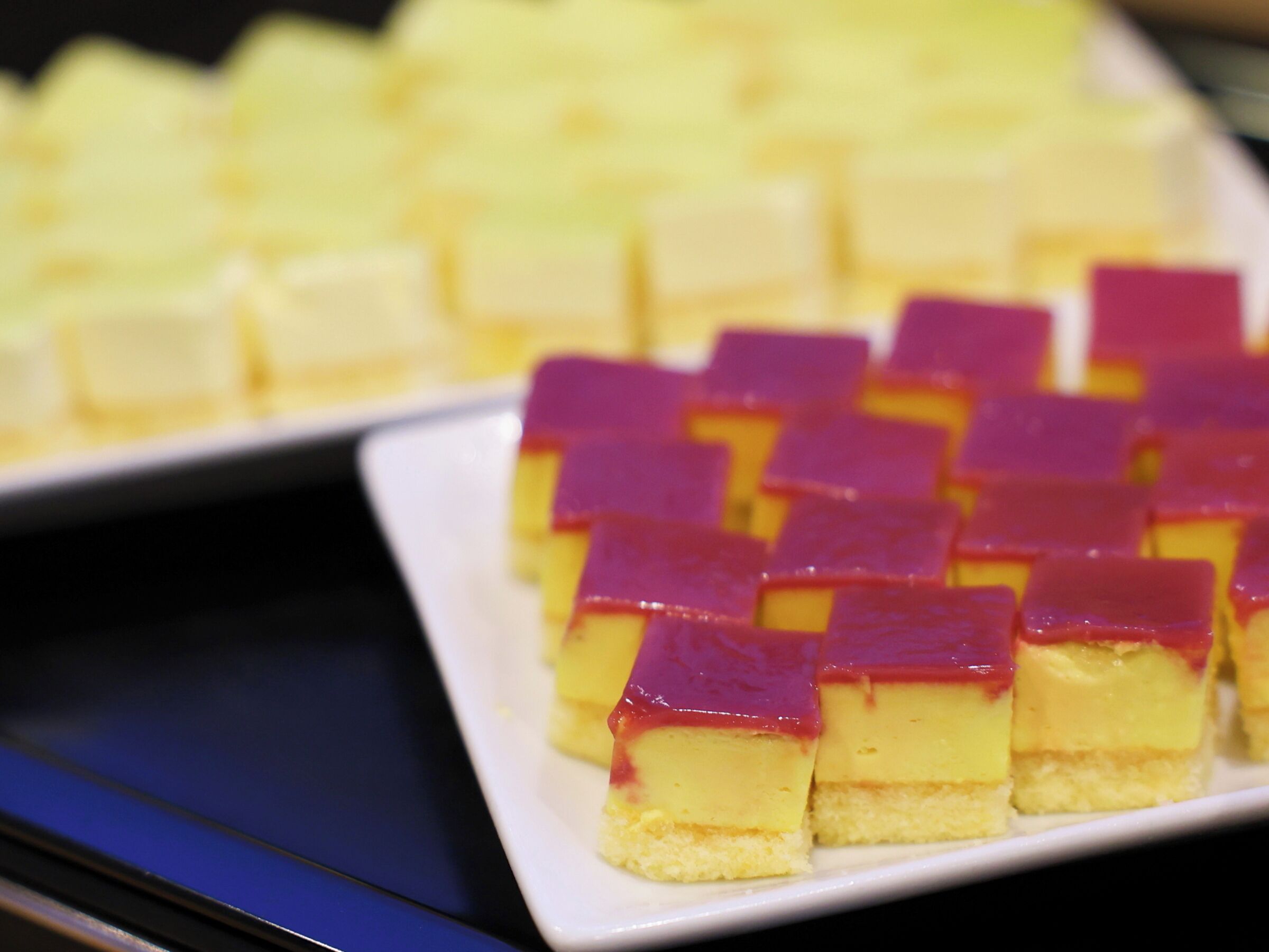 Un plato de postres con capas de color amarillo y morado.