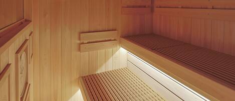 A sauna with wooden walls, a thermometer, and a bench.
