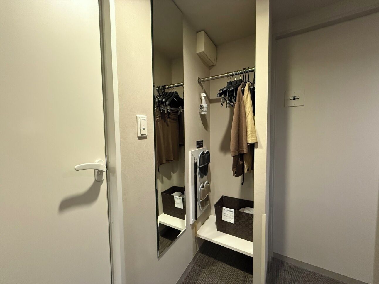 A hotel bathroom with a shower, a towel rack, and a mirror.