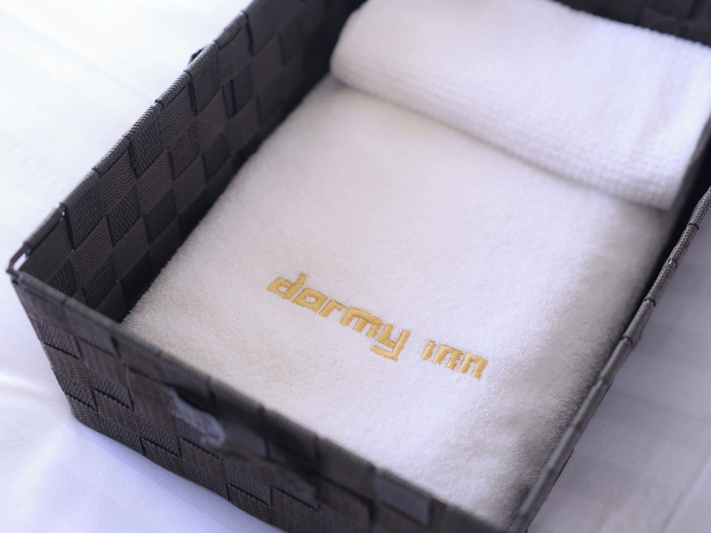 Une boîte à bijoux dont l’intérieur est texturé et sur le couvercle est brodé le mot « dormy ».