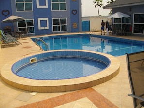 Outdoor pool, pool umbrellas, sun loungers - De Holiday Beach Hotel (Kokrobite)