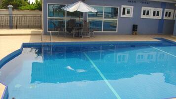 Piscine extérieure, parasols de plage, chaises longues