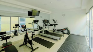 A gym with treadmills, elliptical machines, and stationary bikes.