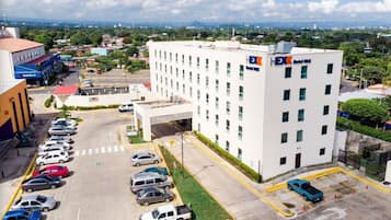 Situated in the heart of the city, DX Hotel offers a modern urban retreat with a flat roof and grid-patterned windows.