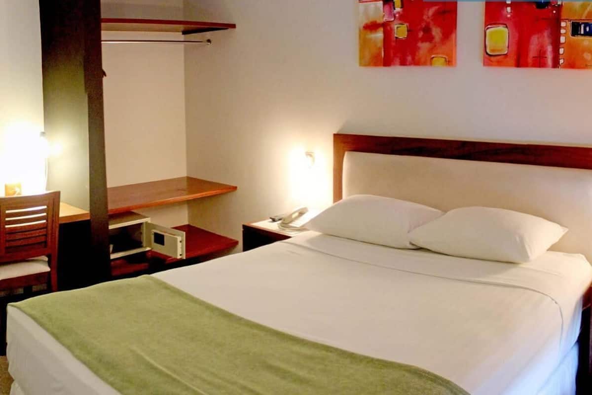 Ropa de cama de alta calidad y caja de seguridad en la habitación