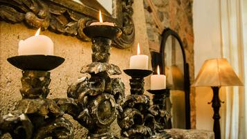 Ornate candle holders with lit candles, a mirror, and a lamp.