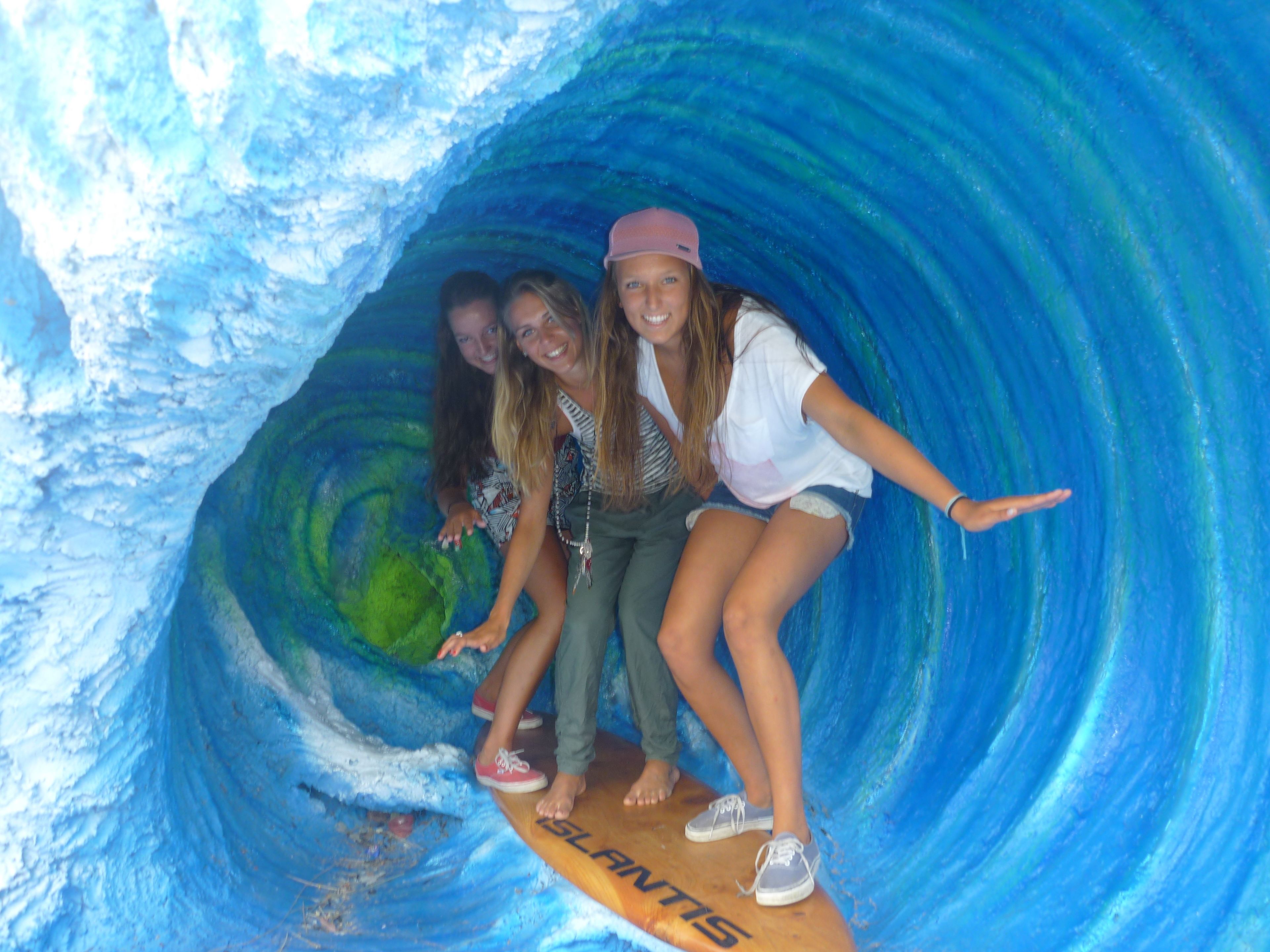 Een groep mensen in een tunnel, met een surfplank aan het einde.