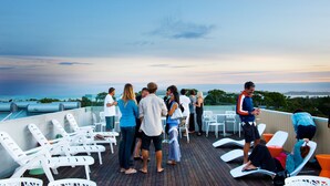 A rooftop terrace with lounge chairs and a view of the ocean. - The Island Accommodation (Newhaven)