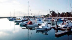 A marina with multiple boats docked at calm water. - The Island Accommodation (Newhaven)