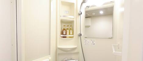 A bathroom with a shower, a towel rack, and a shelf with toiletries.