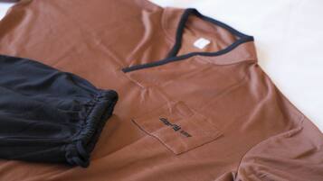 Una camisa marrón con cuello negro y una pequeña etiqueta en el pecho.