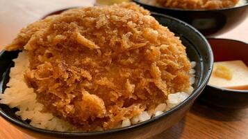 Un bol de rice amb menjar fregit a sobre.