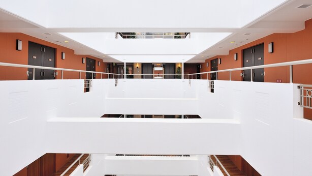 A multi-level interior with a central open space, white railings, and a modern design.