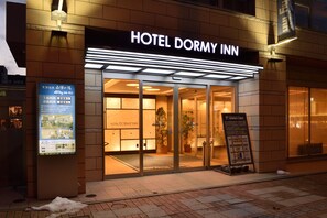 A hotel entrance with a sign reading "HOTEL DORMY INN".