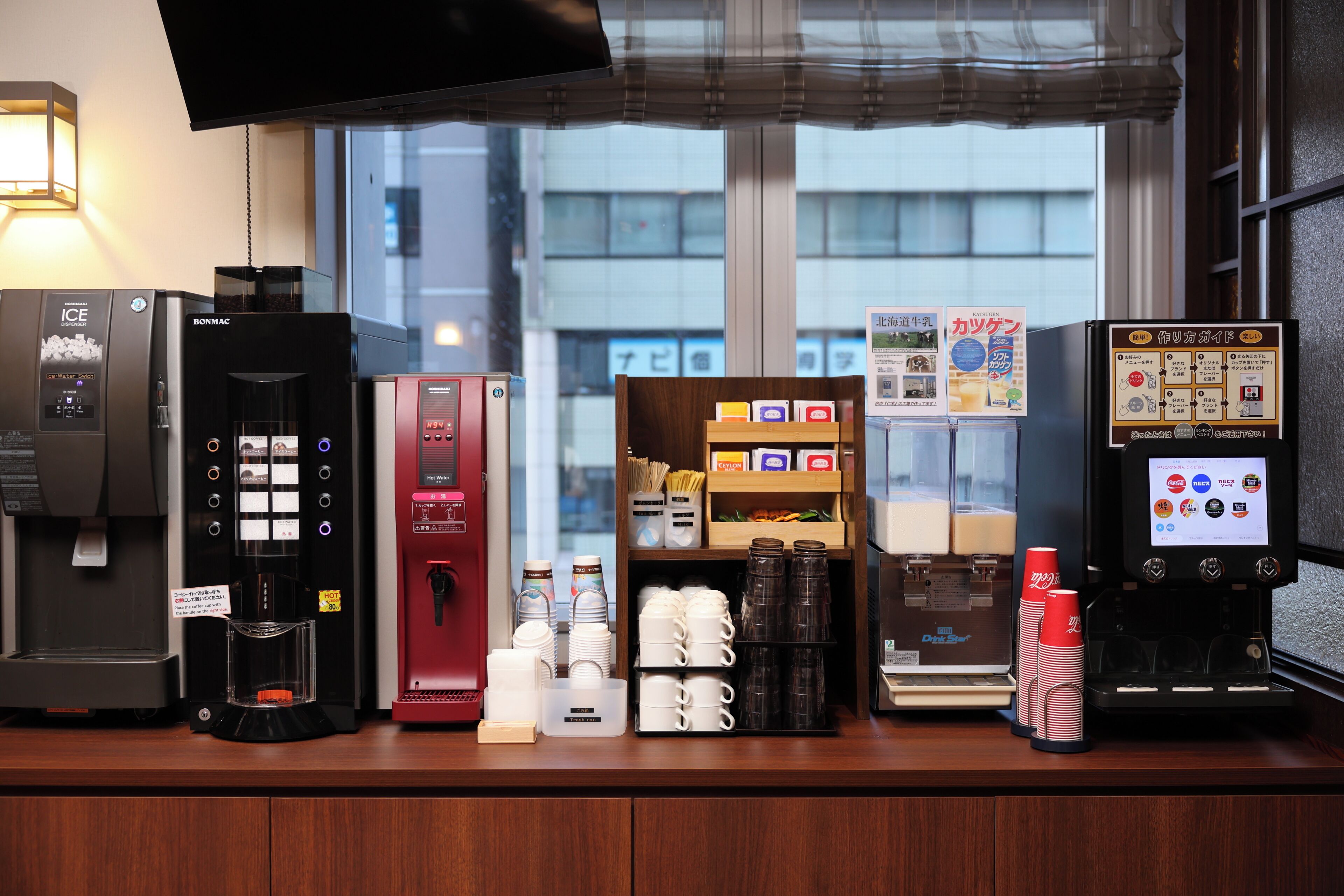 A coffee station with various machines, including an ice dispenser, a hot water dispenser, and a drink dispenser.