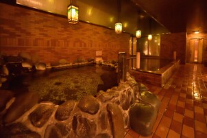A hot spring area with stone seating and lanterns.