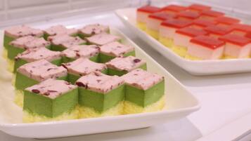 A dessert tray with layered cake and pink mousse pieces.