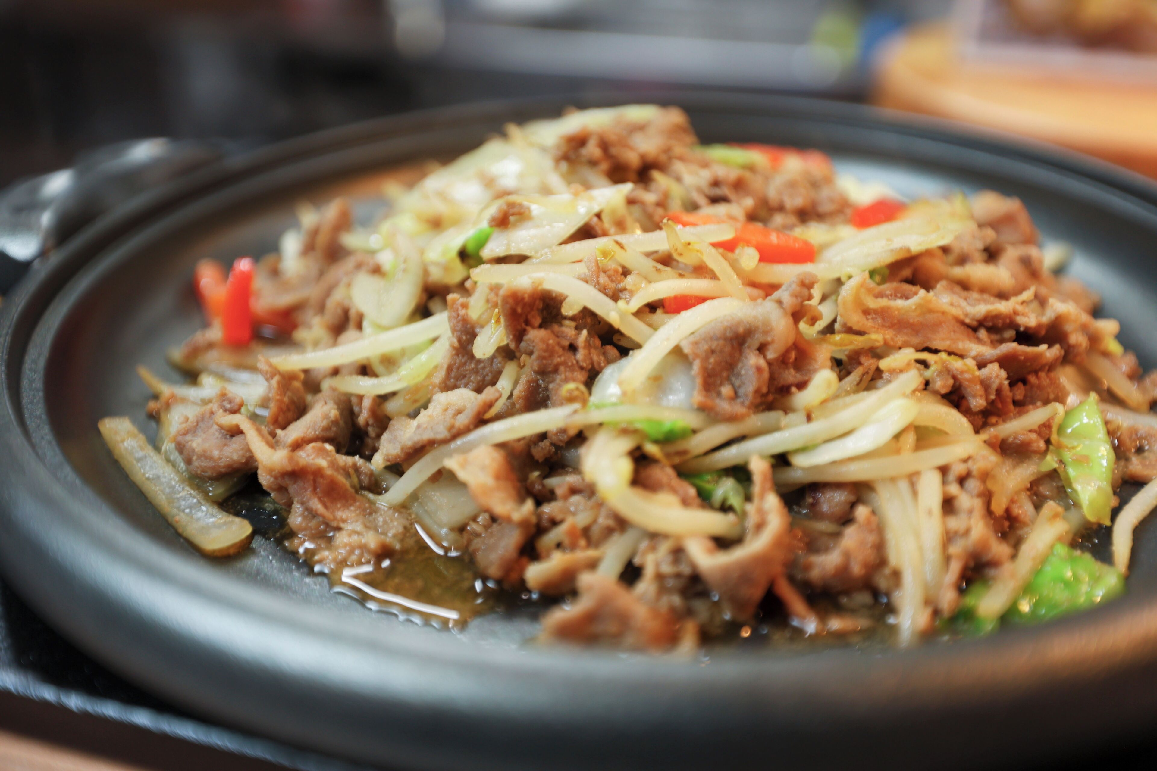Un plato con carne, verduras y salsa.