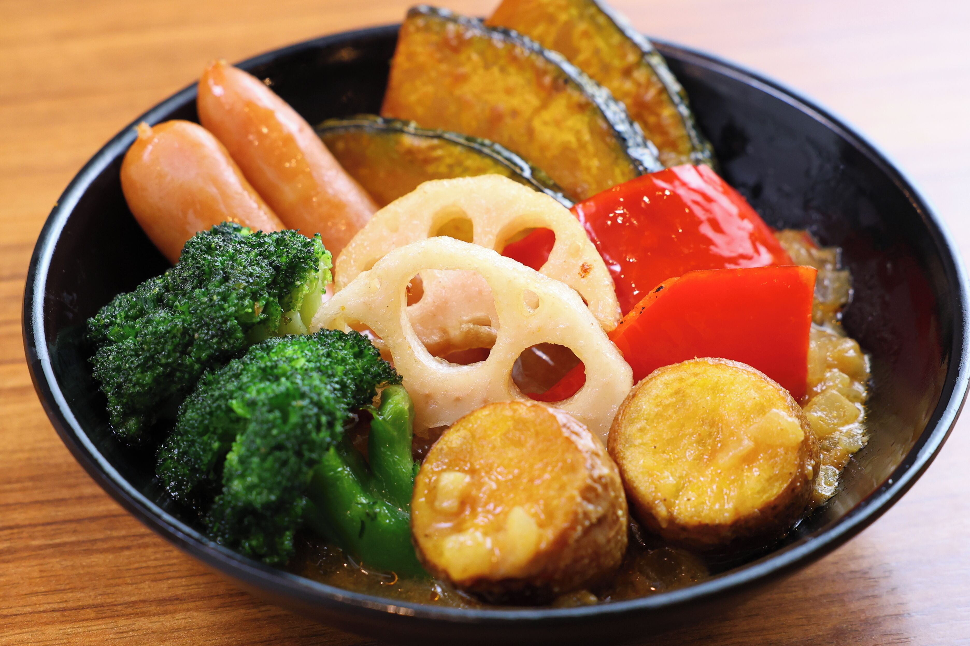 A bowl of assorted vegetables including broccoli, carrots, and sliced potatoes.