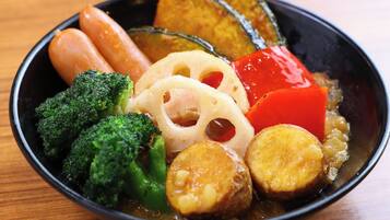 A bowl of assorted vegetables including broccoli, carrots, and sliced potatoes.