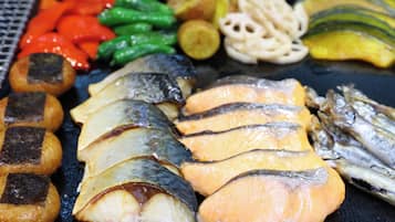 A variety of grilled foods including fish, vegetables, and possibly some dumplings.