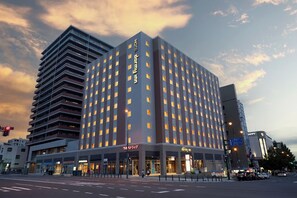 A multi-story hotel with a modern design, featuring a prominent 'Inn Inn' sign on the facade. - Dormy Inn Premium Otaru Natural Hot Spring (Otaru)
