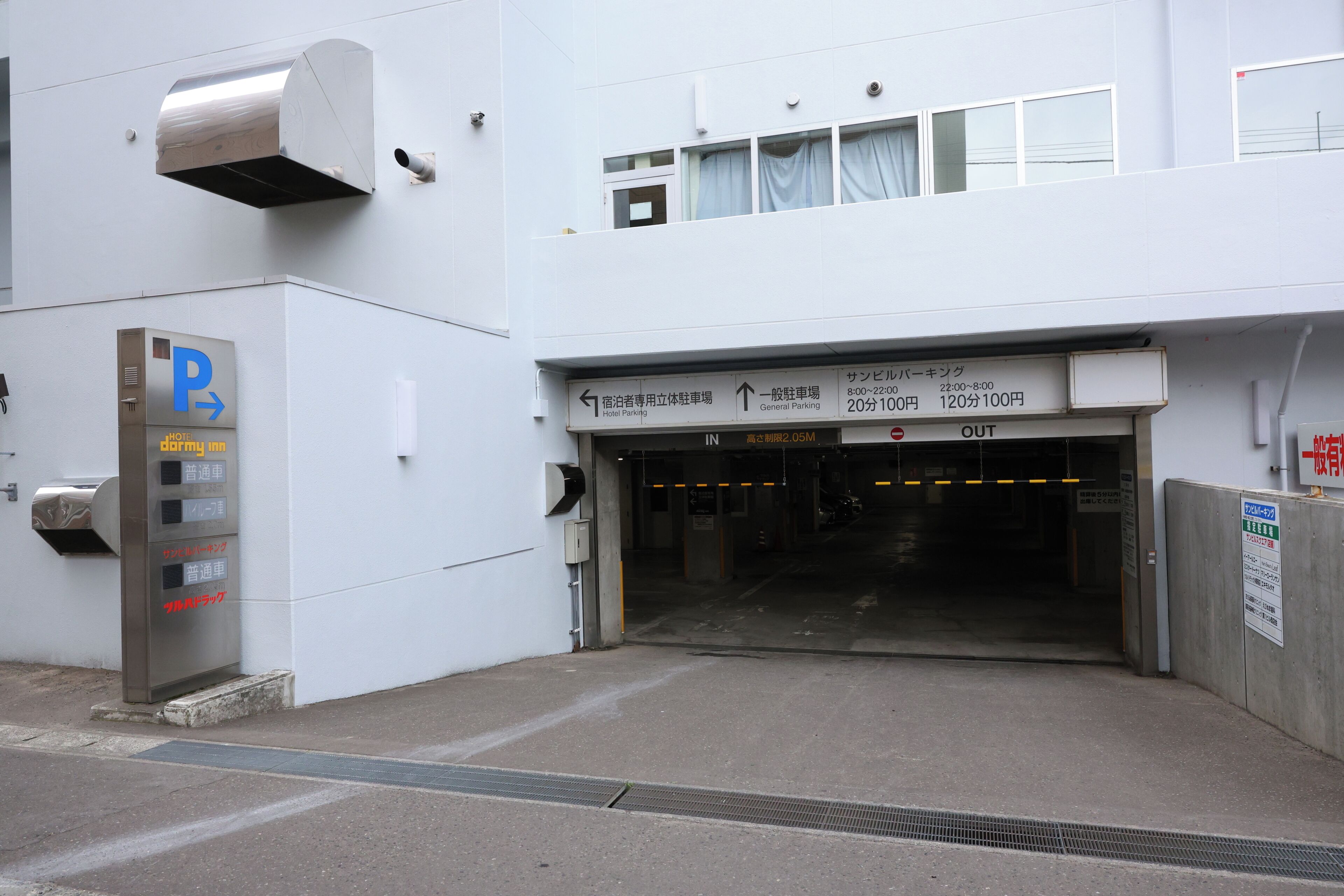 A hotel entrance with a parking sign, a general parking area, and a hotel parking section.