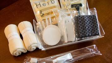 A set of toiletries including a body towel, a brush, and a container labeled "Herb & Jasmin."