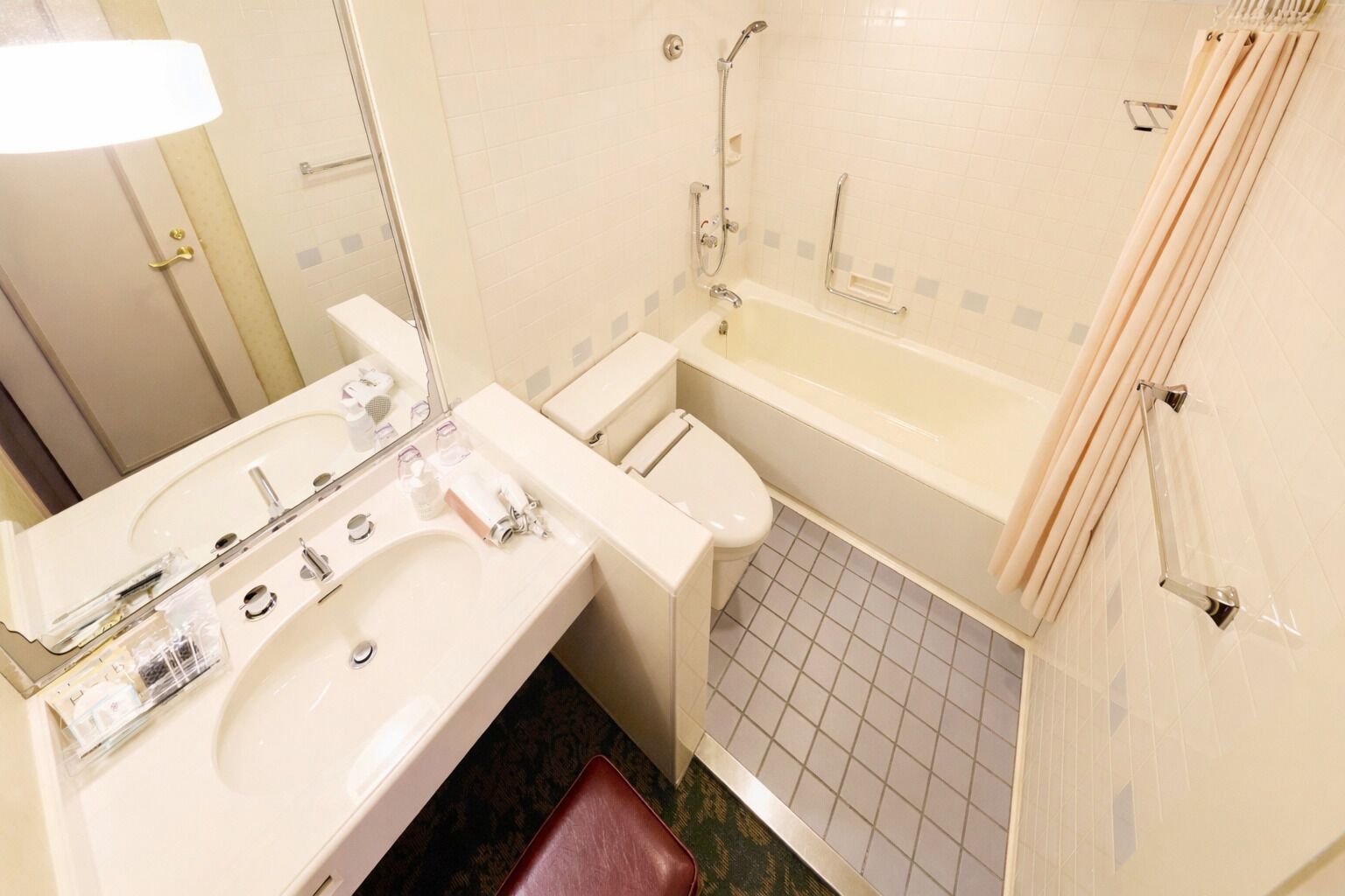 Une salle de bain équipée d’un lavabo, d’un miroir, de toilettes et d’une baignoire.