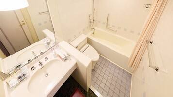 Une salle de bain équipée d’un lavabo, d’un miroir, de toilettes et d’une baignoire.