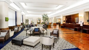 A spacious lobby with multiple seating areas, a reception desk, and a large mirror. - Hotel Den Haag Huis Ten Bosch (Sasebo)