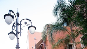 A curved pathway leading to a building with balconies and a street lamp. - Artemis Hotel (Cefalù)
