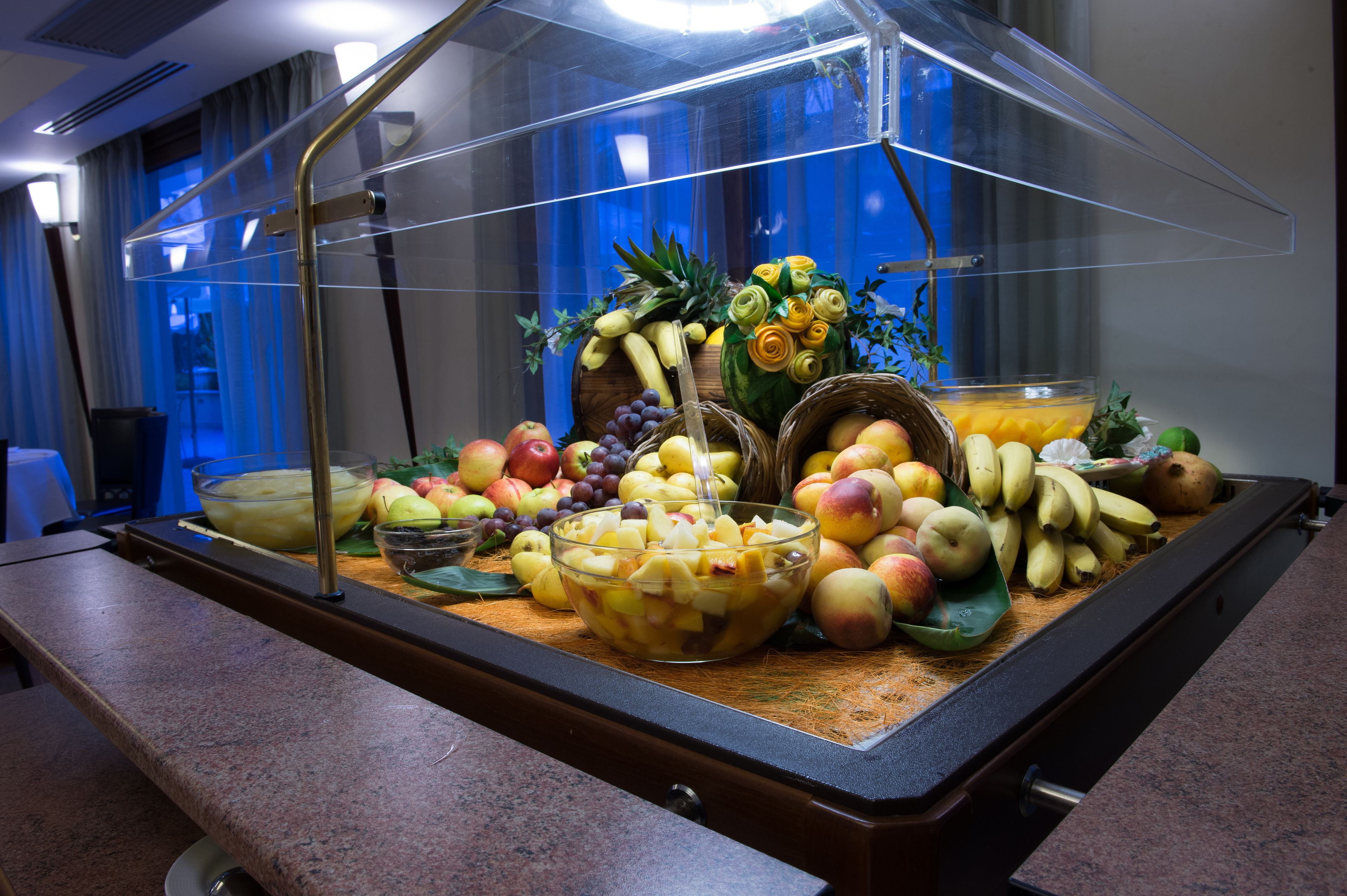 Un bufé con una variedad de frutas y un bol de fruta mixta.
