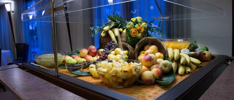 Un bufé con una variedad de frutas y un bol de fruta mixta.