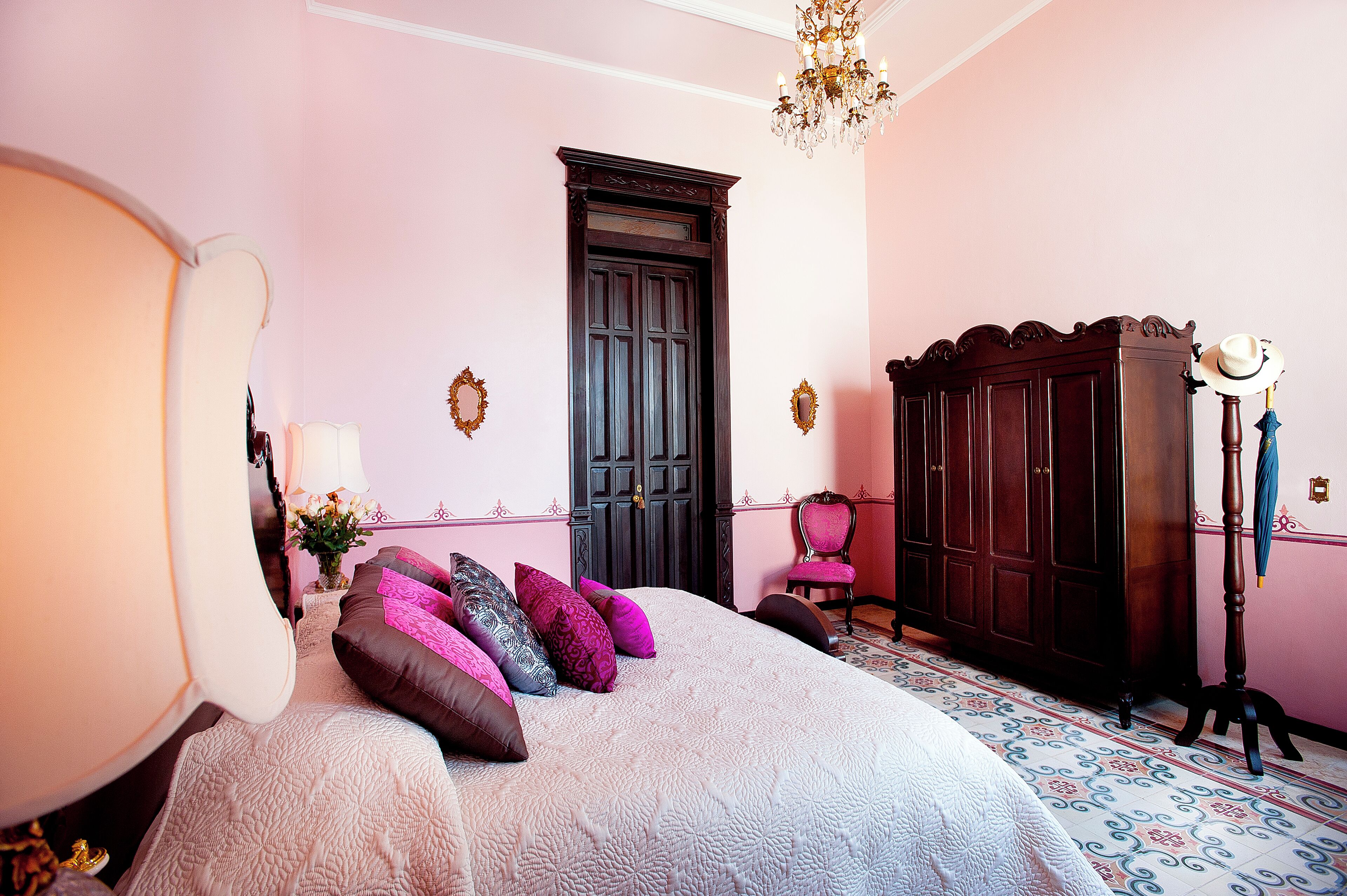 Un dormitorio con una cama grande, un aparador, una silla y un armario.