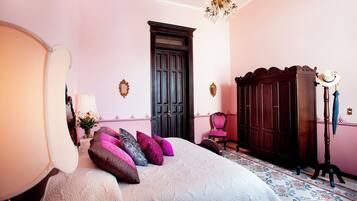 Un dormitorio con una cama grande, un aparador, una silla y un armario.