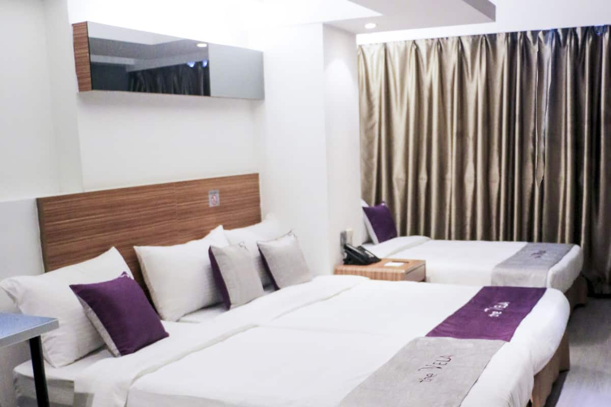 Ein Hotelzimmer mit zwei Betten, einem Schreibtisch und einem Spiegel.