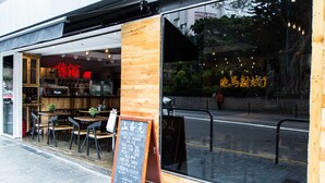 A restaurant with a wooden exterior, a chalkboard menu, and outdoor seating. - Vela Boutique Hotel (Hong Kong)