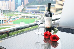 A table with a bottle of wine, two wine glasses, and two red roses. - Vela Boutique Hotel (Hong Kong)