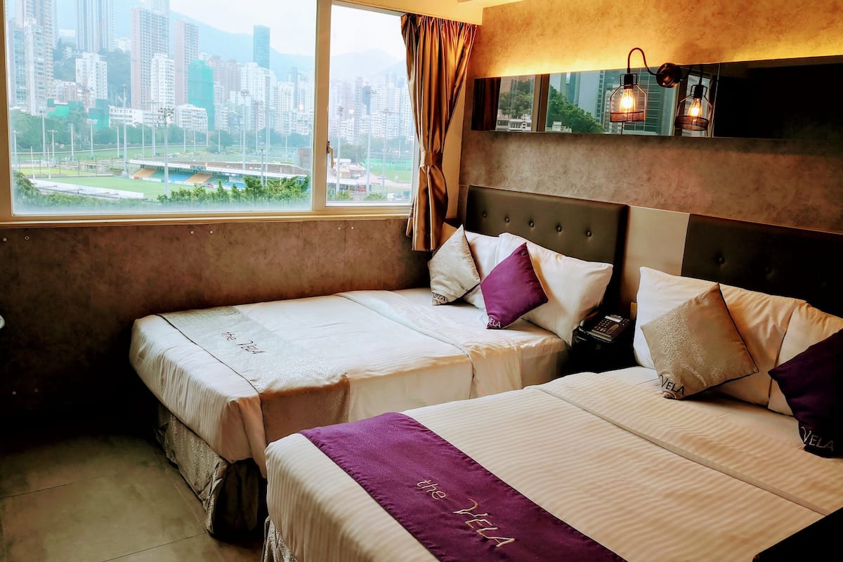 Ein Hotelzimmer mit zwei Betten, Blick auf die Stadt und modernem Design.