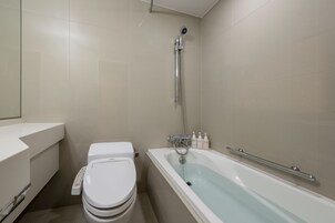 A bathroom with a toilet, a bathtub, and a shower.