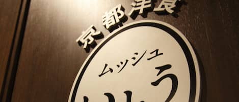 Un letrero con caracteres japoneses y el texto 'DESDE 1961' sobre una superficie de madera.