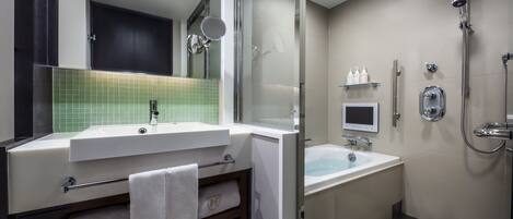 Une salle de bain moderne dotée d’un meuble-lavabo à deux vasques, d’une douche à parois de verre et de toilettes intégrées.