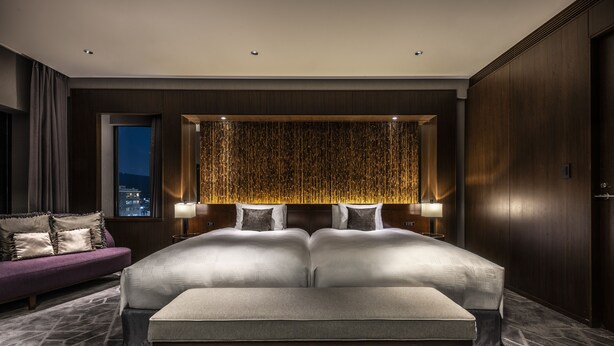 A modern bedroom with a large bed, a nightstand, a sofa, and a city view. - The Royal Park Hotel Kyoto Sanjo (Kyoto)