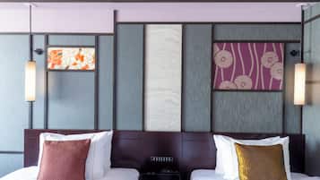 Habitación de hotel con cama, dos almohadas, panel de control y paneles decorativos en la pared.