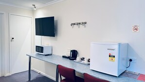 A kitchenette with a microwave, coffee maker, and a Husky refrigerator. - Edinburgh Motor Inn (Warragul)