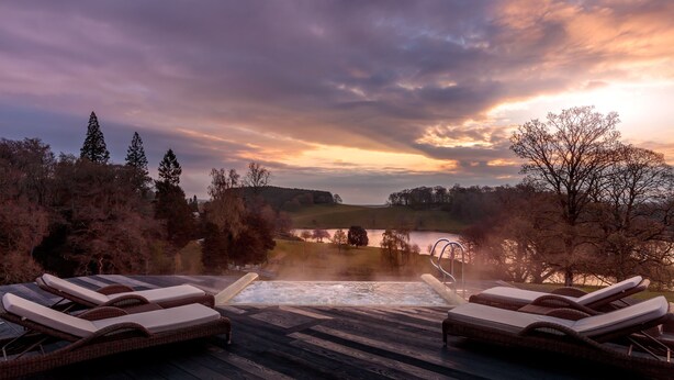 A hot tub area with lounge chairs and a view of a lake and hills. - The Coniston Hotel and Country Estate (Skipton)